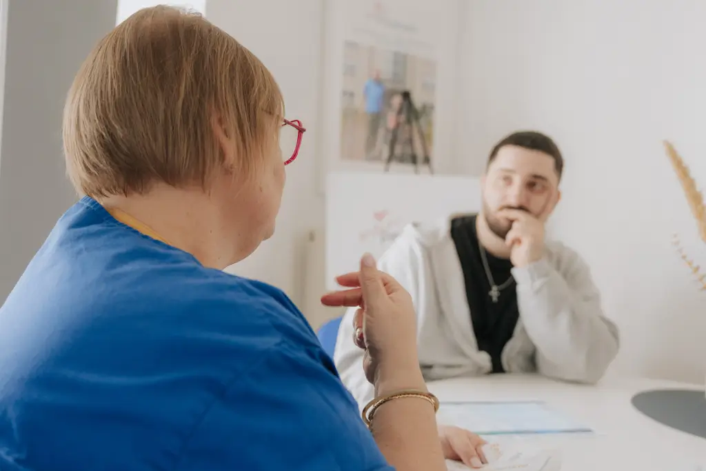 Zwei Personen sitzen sich an einem Tisch gegenüber und führen ein Gespräch